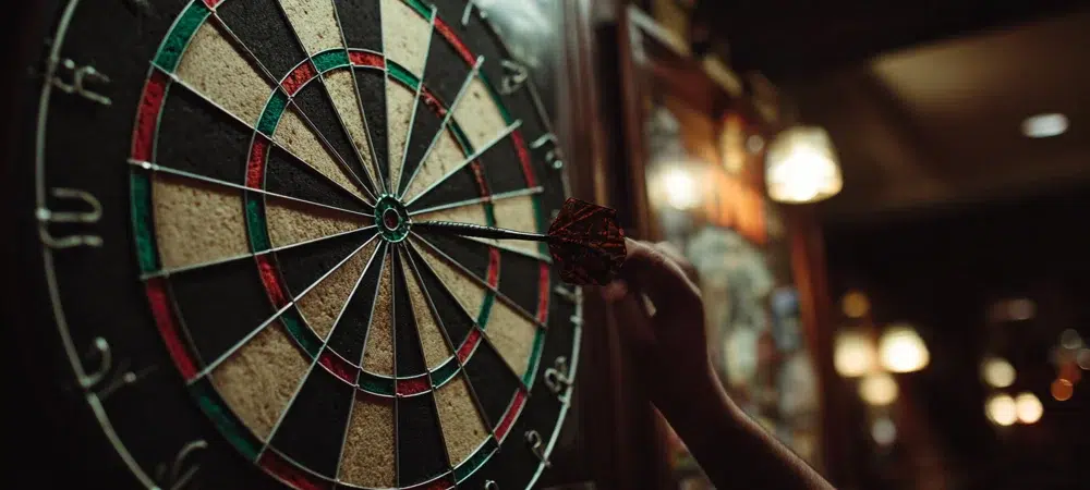 a person taking out a dart out of the dart board