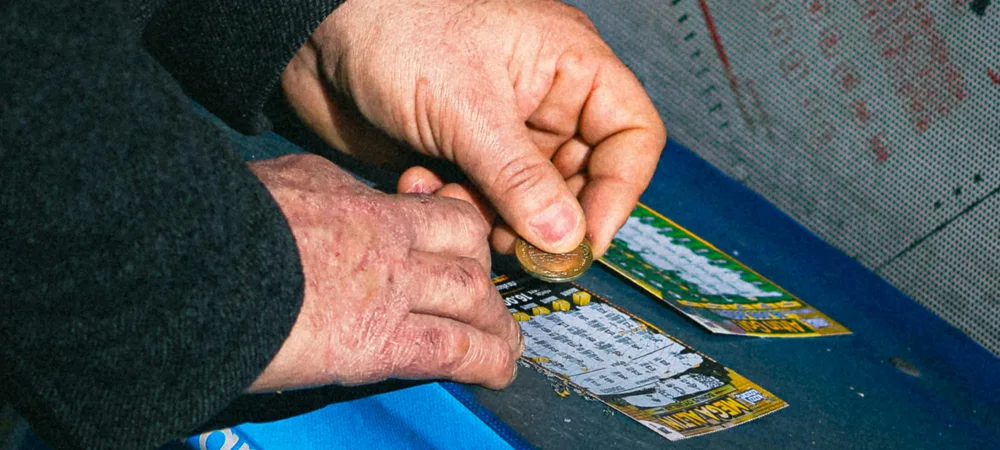 a person scratching lottery tickets with a coin