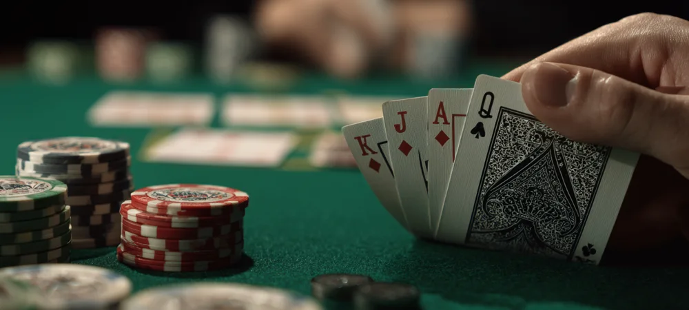 a person sitting at a poker table checking the cards in their hand